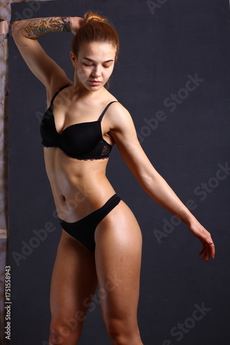 Beautiful young sexy cheerleader girl in black with tattoo on hand.