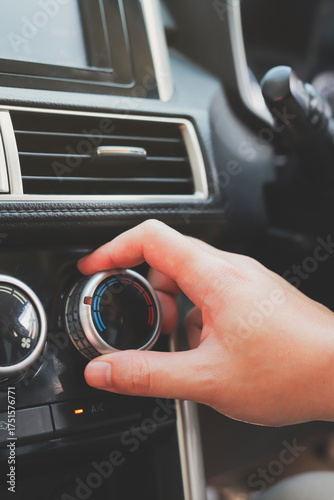 close up hand air conditioning and center console of car for temperature.