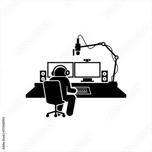 Person at computer desk with microphone headphones and dual monitors
