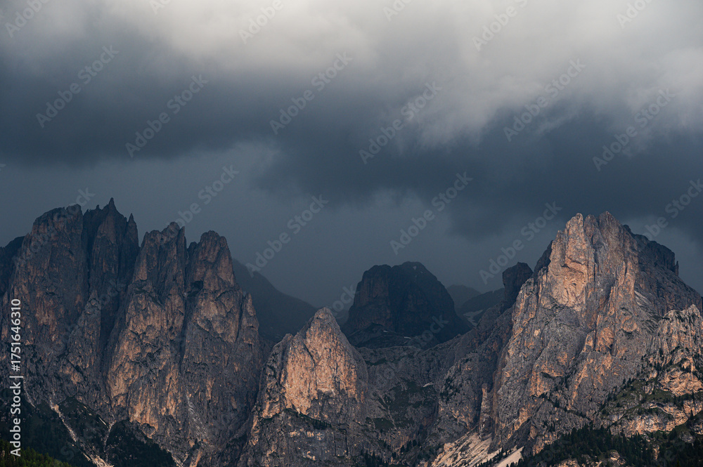 Fototapeta premium moutain Catinaccio range seen from Pozza di Fassa with a cloudy sky in the background, Val di Fassa, Trento, Italy