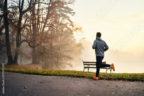 Fotografija Man jogging on a foggy autumn morning in park