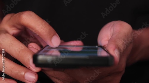 Man's hands holding a smartphone and scrolling the social media apps