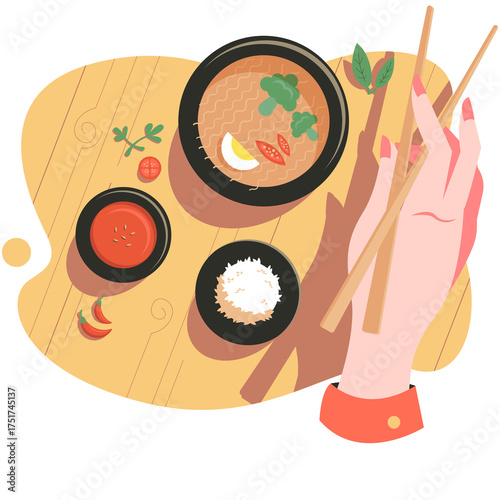 Top View Overhead of Woman Hand Holding Chopsticks About to Eat Noodle Soup Bowl with Red Chili Sauce and White Rice on Yellow Wooden Table