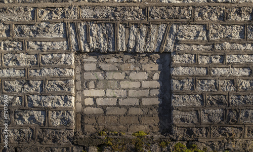 A bricked-up window opening in a vintage limestone house wall