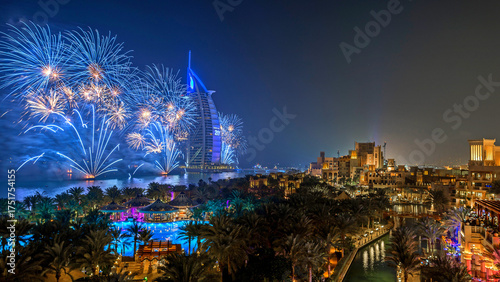 Fotografie Spectacular night view of Dubai city with dazzling fireworks surrounding the Burj Khalifa, the tallest building in the world
