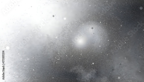 Abstract image showcasing a bright, central light source surrounded by textured, diffused shapes and particles.