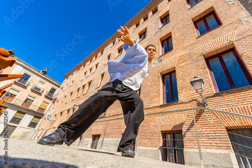 Fotografija Young man performing flamenco street dance in urban setting