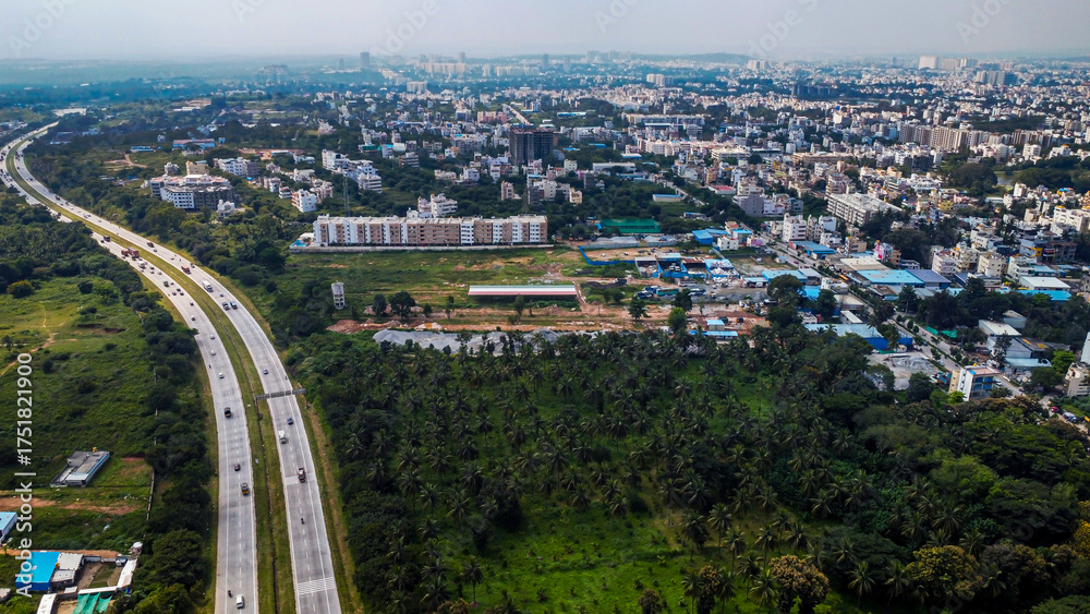 Obraz premium Arial shot of Beautiful road infrastructure of karnataka in India. Aerial view city traffic Highway road with car vehicle movement