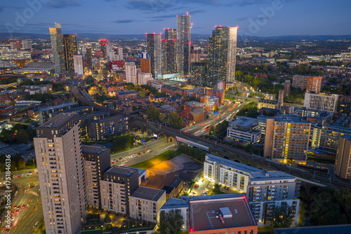 Wall Mural Aerial view flying towards Castlefield and Deansgate in Manchester during blue hour with skyline lights glowing