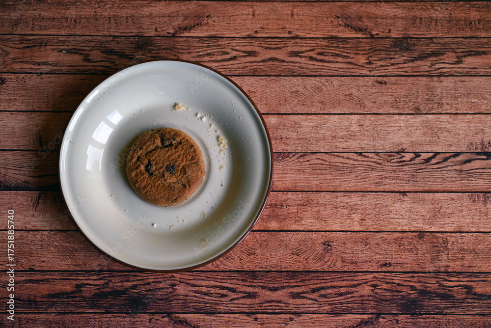 Obraz premium oatmeal cookies on a white saucer on a wooden table