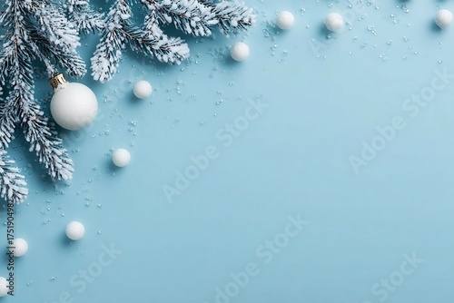 Christmas minimal concept - Christmas composition with snowy fir branch and white bauble. Horizontal top composition, flat lay, view from above. Pastel blue background with copy space