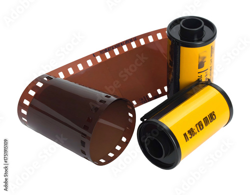 Rolled 35mm film canisters, with a strip of exposed film unfurled nearby