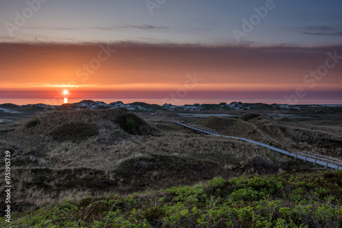 Amrum island, Germany: sun rays emerging through the dark storm clouds at the beach of Amrum. 