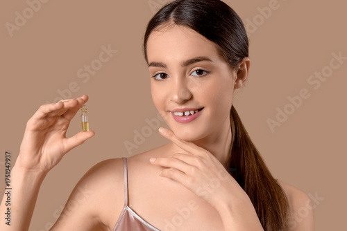 Young woman with ampoule on...