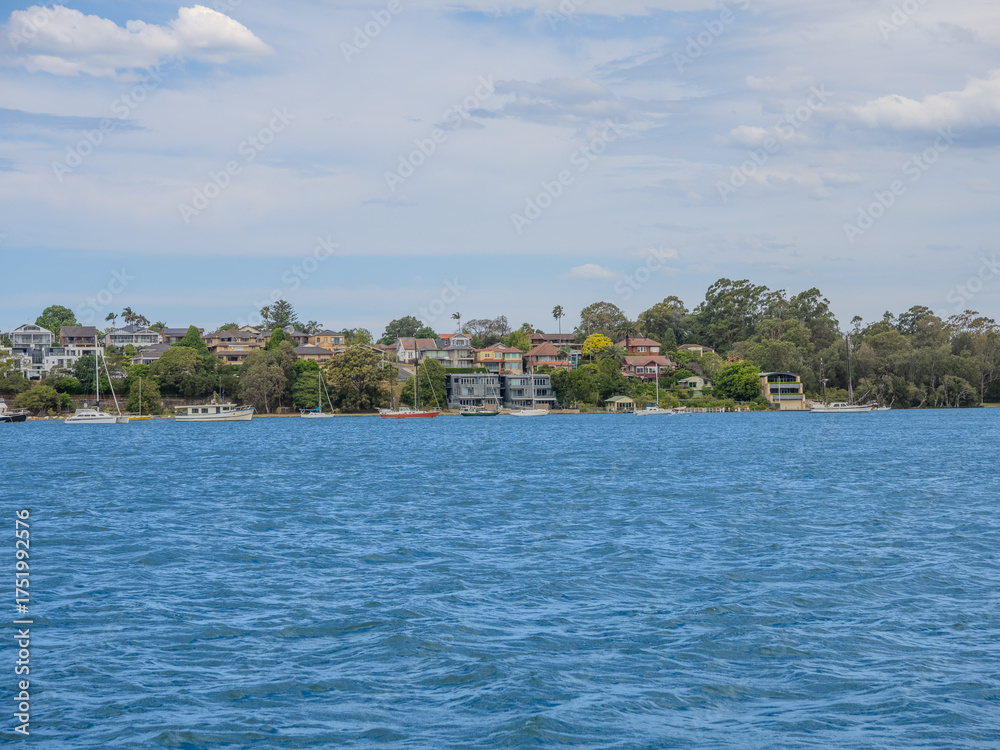 Fototapeta premium 11 October 2025 Residential Houses and apartment buildings on Parramatta River Sydney Harbour on a warm spring cloudy overcast day in Sydney NSW Australia