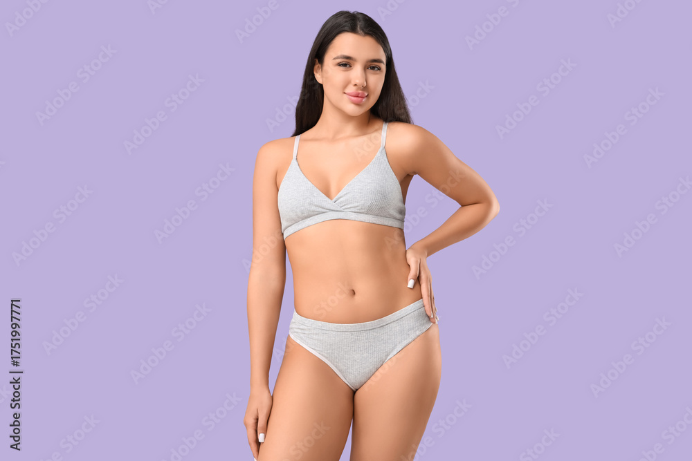 Fototapeta premium Beautiful young woman in underwear on lilac background