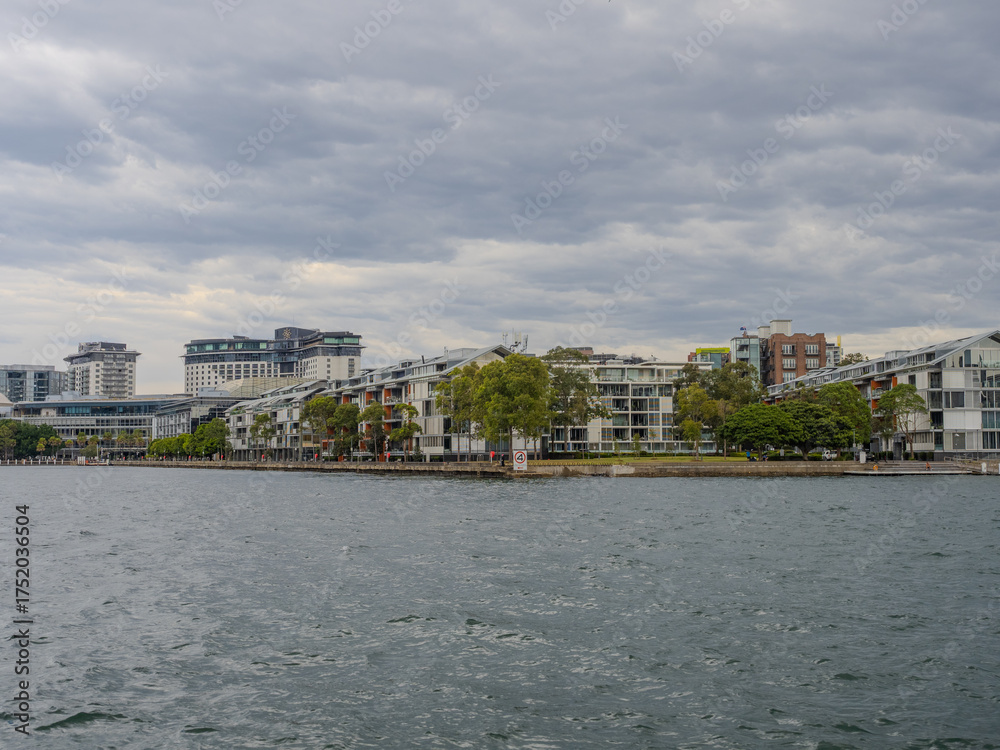 Obraz premium 11 October 2025 Residential Houses and apartment buildings on Parramatta River Sydney Harbour on a warm spring cloudy overcast day in Sydney NSW Australia