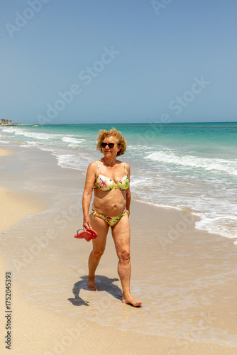 Wallpaper Mural attractive senior woman at the beautiful sandy beach in bikini Torontodigital.ca