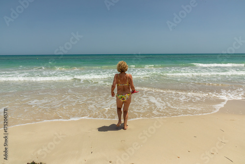 Wallpaper Mural attractive senior woman at the beautiful sandy beach in swim suit Torontodigital.ca