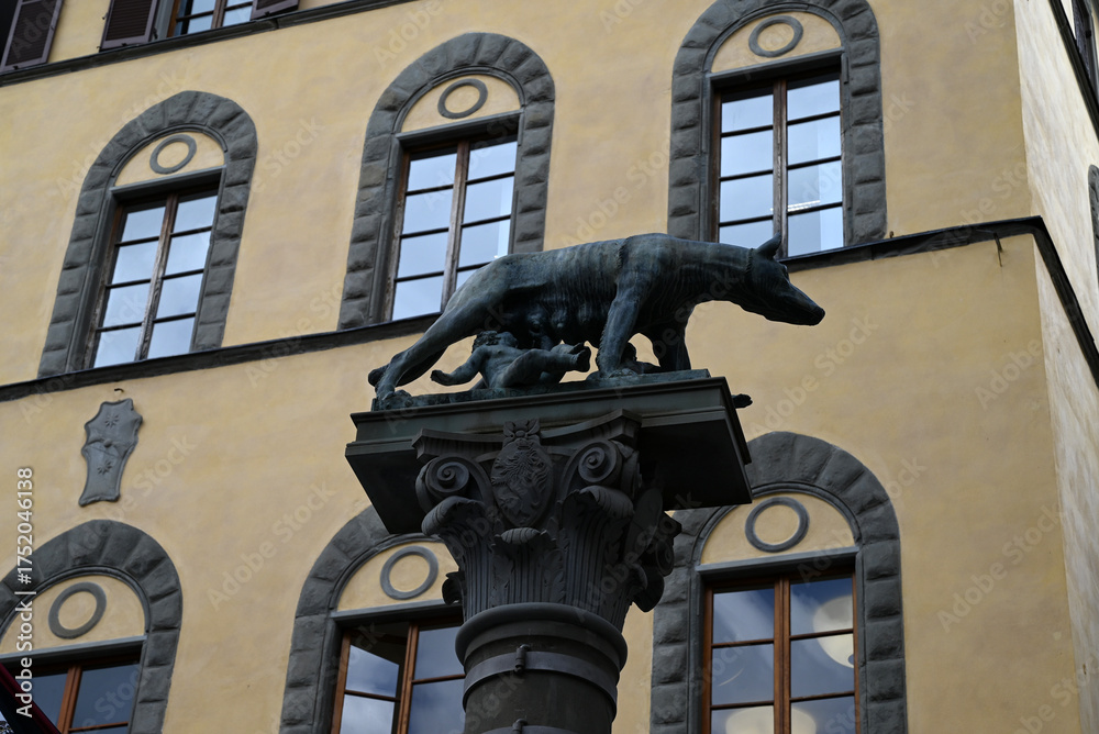 Naklejka premium Sienne, Italie, 15 septembre 2025 : Statue de Romulus et Rémus avec la louve sur la Piazza Tolomei dans la ville de Sienne