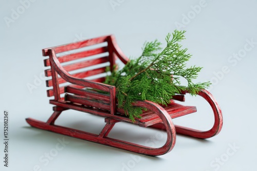 Minimalist photo of a small red wooden sled carrying a pine tree on a light background, simple, modern, and elegant holiday composition.