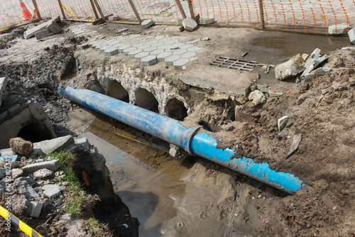 Blue water pipe exposed in excavation trench during infrastructure work in Campeche, Florianópolis - Brazil