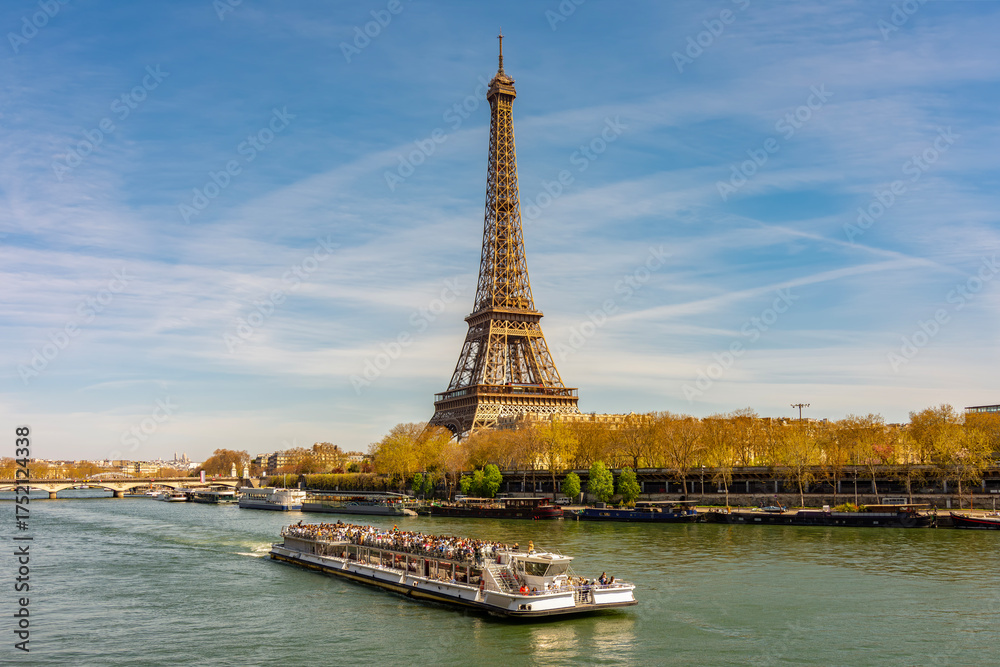 Fototapeta premium Eiffel Tower and cruise boat on Seine river in Paris, France