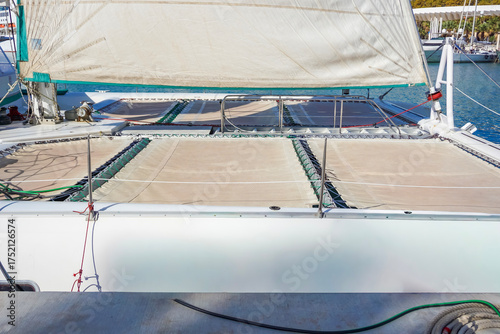 Photography close up of the netting trampolines and foresail of a catamaran docked in a mari