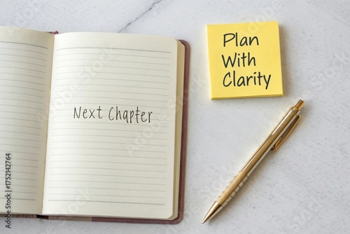 An open journal and sticky note next to a pen on a marble surface, ready to plan