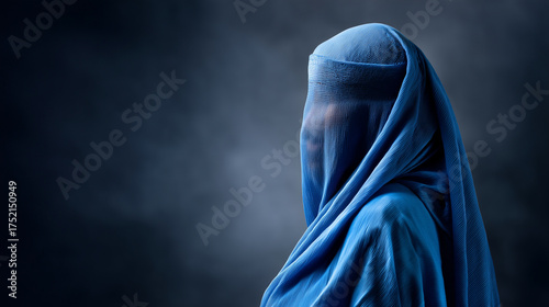 Woman wearing a traditional blue burqa standing against a dark background, symbolizing culture, identity, and the complex layers of tradition and privacy. Afghan culture, burqa por
