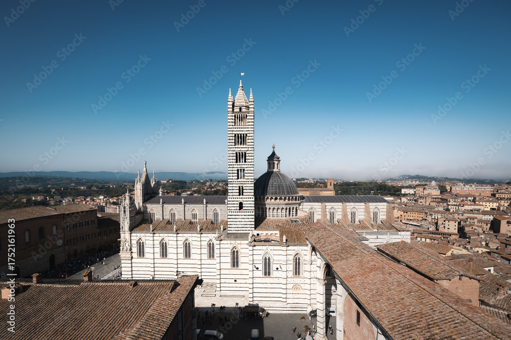 Fototapeta premium Aerial rooftop view of Duomo di Siena gothic cathedral, dome and bell tower, Italy