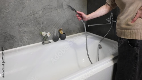 spraying of water from a shower head when rinsing the bathtub