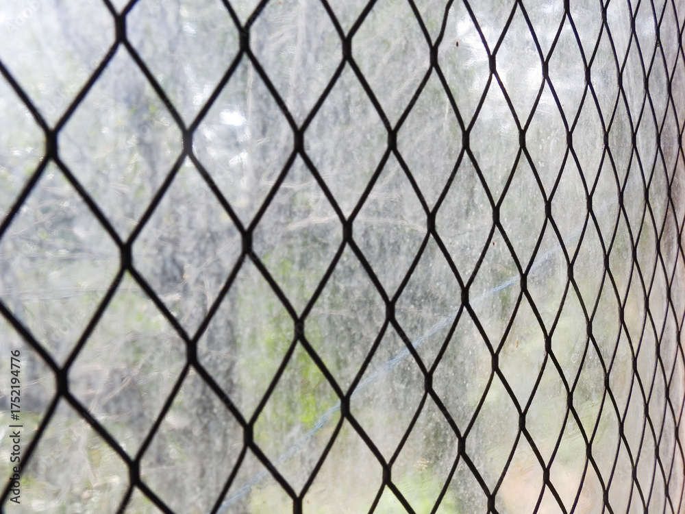 Fototapeta premium Stretched metal mesh on a blurred background