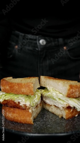 Rotating plate with sliced chicken Caesar toast sandwich – food close up