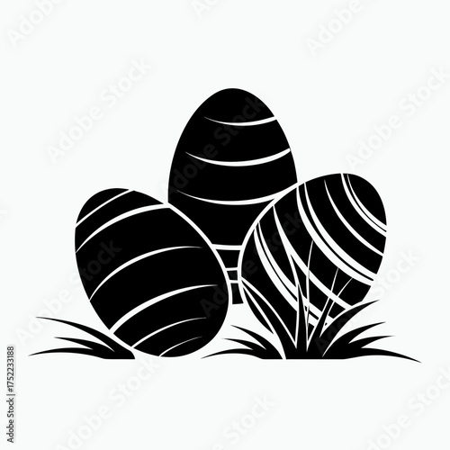 Black Easter eggs with stripes nestled in grass isolated on a white background  