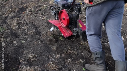 Wallpaper Mural Individual operating a tiller in a garden, showcasing the process of soil preparation, with a gradual zoom in capturing the action and equipment details	 Torontodigital.ca