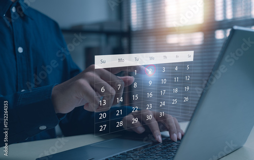 Businessman using laptop and touching virtual calendar date 2, concept of digital planning, schedule management, online productivity, time control, and modern technology workspace.