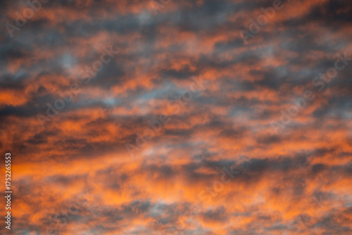 Spektakuläre Morgenstimmung: Dramatische Wolkenformationen in leuchtendem Orange und Dunkelgrau beim Sonnenaufgang (oder Sonnenuntergang).