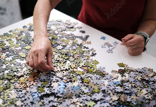 Hands Assembling Puzzle Pieces Into A Picture
