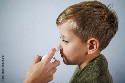 Mom treating child’s runny nose with saline wash