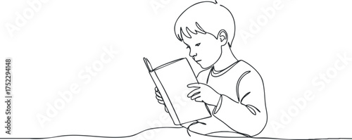A young boy deeply engaged in reading a book, showcasing concentration and curiosity.