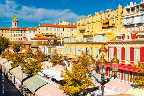 Cours Saleya Square in Nice during the market, with stalls set up between the buildings, illuminated by the autumn, October sun
