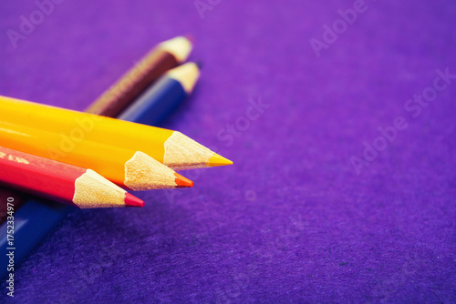 Five multicolored pencils on a purple felt background. Different colored pencils with space for text. Back to school. Art lessons.