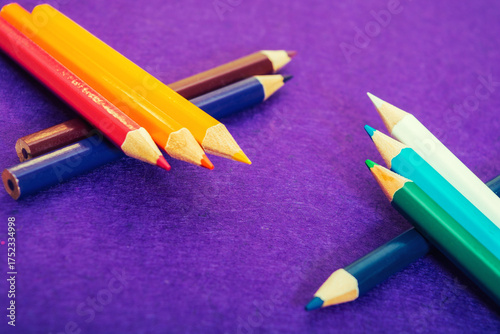 Nine multicolored pencils on a purple felt background. Different colored pencils with space for text. Back to school. Art lessons.