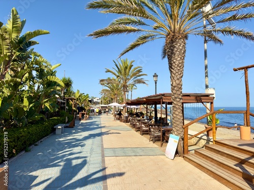Schilderij op canvas promenade with palms, restaurants and beach at the coast of San Pedro de Alcánta