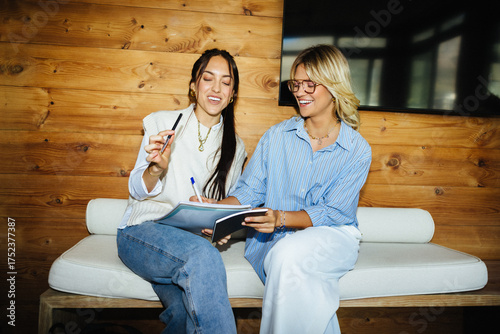 Young women collaborating with notebooks in startup workspace