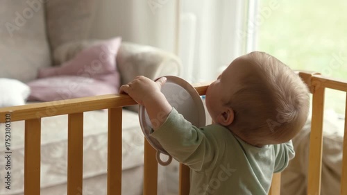 In the crib, the baby learns to stand, thereby demonstrating his natural curiosity and interest in the warm and brightly lit home environment