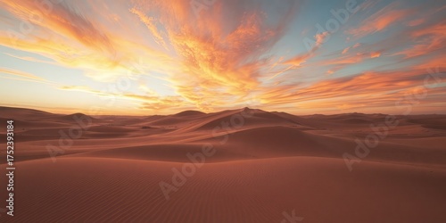 Fototapeta Naklejka Na Ścianę i Meble -  Dramatic orange sunset paints the sky above undulating sand dunes in a vast and serene desert landscape, evoking a sense of tranquility and adventure.