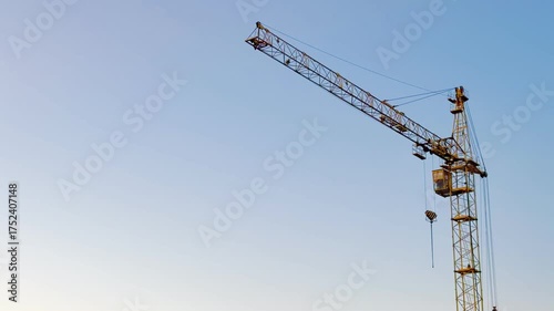 Crane over the horizon shot wide: the jib outlines the sky — industrial geometry.