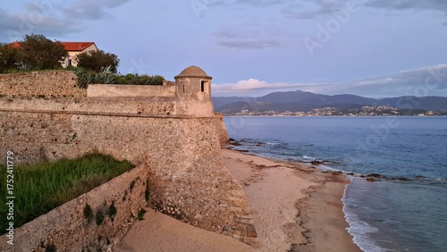 The powerful high walls of the old Corsican fortress on the seashore